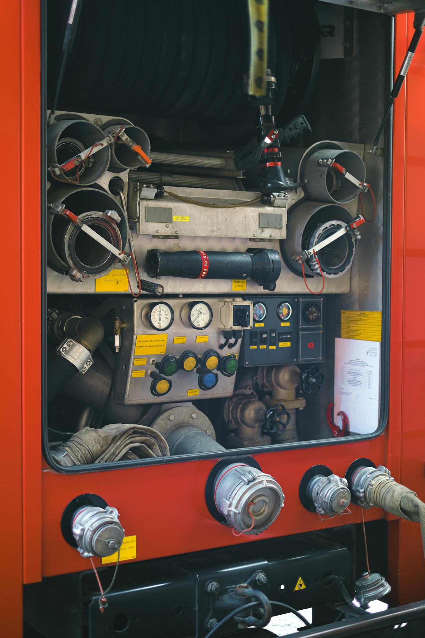 Detailed shot of a fire truck's equipment panel with hoses and gauges.